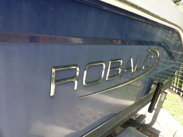Slide: The Image of 2019 Robalo R207 boat with metallic logo on blue hull. - 4