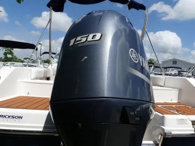 Slide: The Image of 2019 Robalo R207 boat with Yamaha 150 outboard motor, docked under a sunny sky. - 6