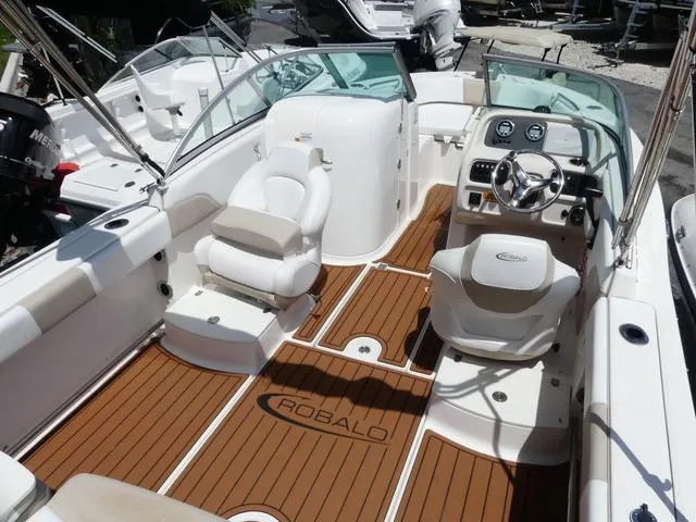 Slide: The Image of 2019 Robalo R207 boat interior with wood flooring and white seating. - 7