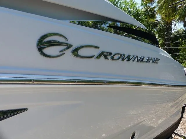 Slide: The Image of 2018 Crownline E23 XS boat side view with logo, outdoors. - 4