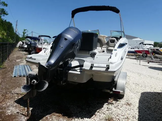 Slide: The Image of 2018 Crownline E23 XS boat with outboard motor on a trailer, parked outdoors. - 5