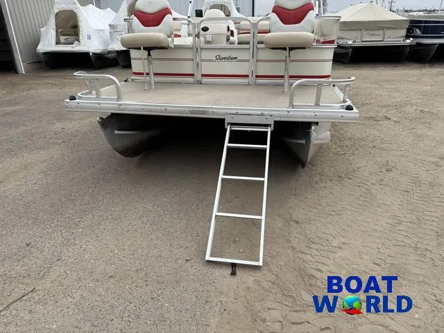 Slide: The Image of 2006 Sun Tracker Party Barge 20 Pontoon with ladder, parked on sandy ground. - 15