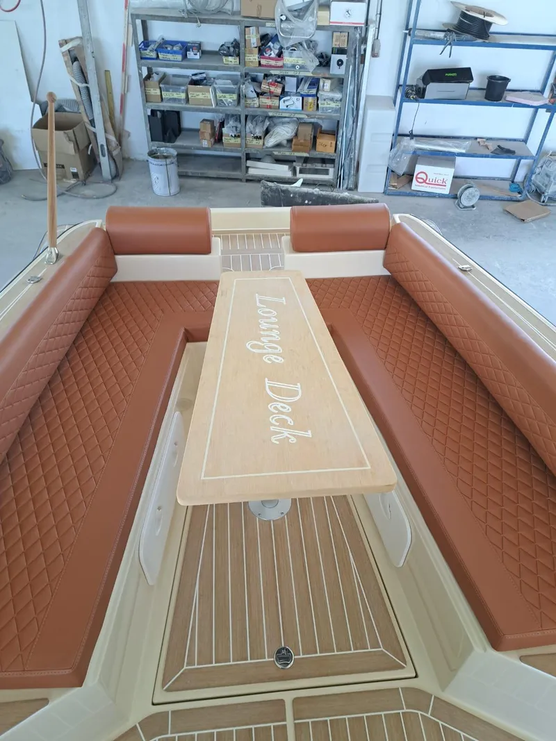 Slide: The Image of 2025 Lilybaeum Levanzo 25 Lounge Deck with brown quilted seating and wooden table. - 23