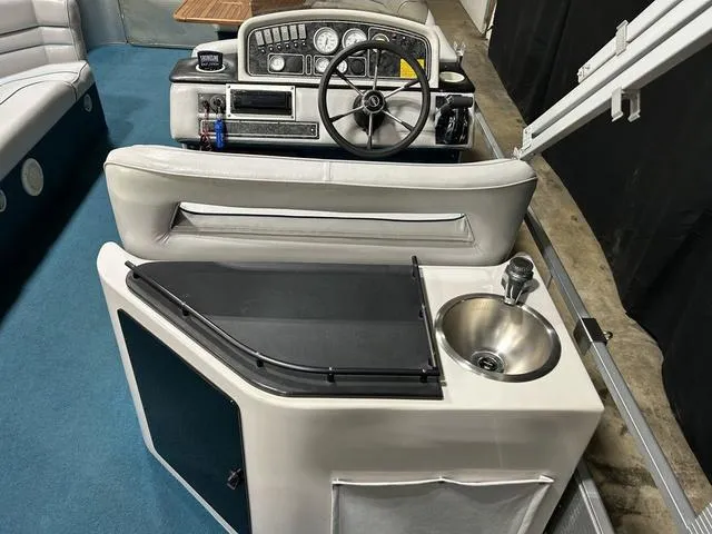 Slide: The Image of 1994 Harris-Kayot Heritage 2400 boat interior with steering wheel and sink. - 17