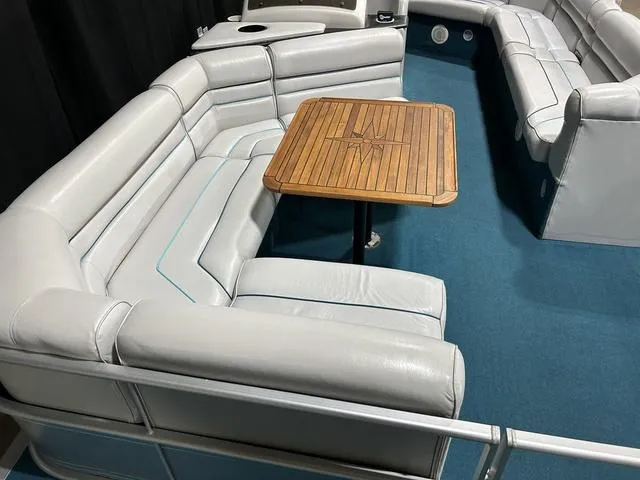 Slide: The Image of 1994 Harris-Kayot Heritage 2400 boat interior with white seating and wooden table. - 25