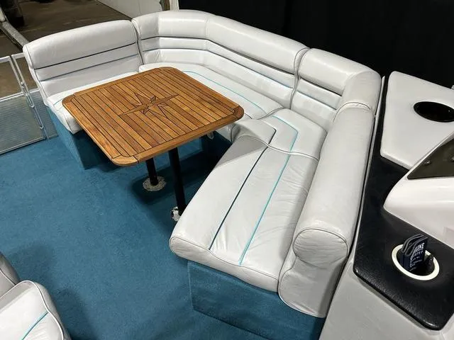 Slide: The Image of 1994 Harris-Kayot Heritage 2400 boat interior with white seating and wooden table. - 26