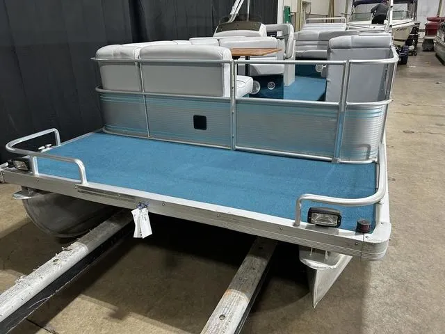 Slide: The Image of 1994 Harris-Kayot Heritage 2400 pontoon boat with blue deck and seating, indoors. - 6