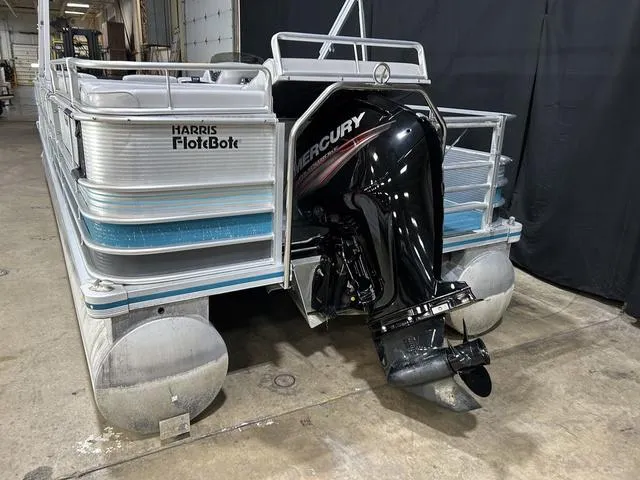 Slide: The Image of 1994 Harris-Kayot Heritage 2400 pontoon boat with Mercury outboard motor in a warehouse setting. - 8