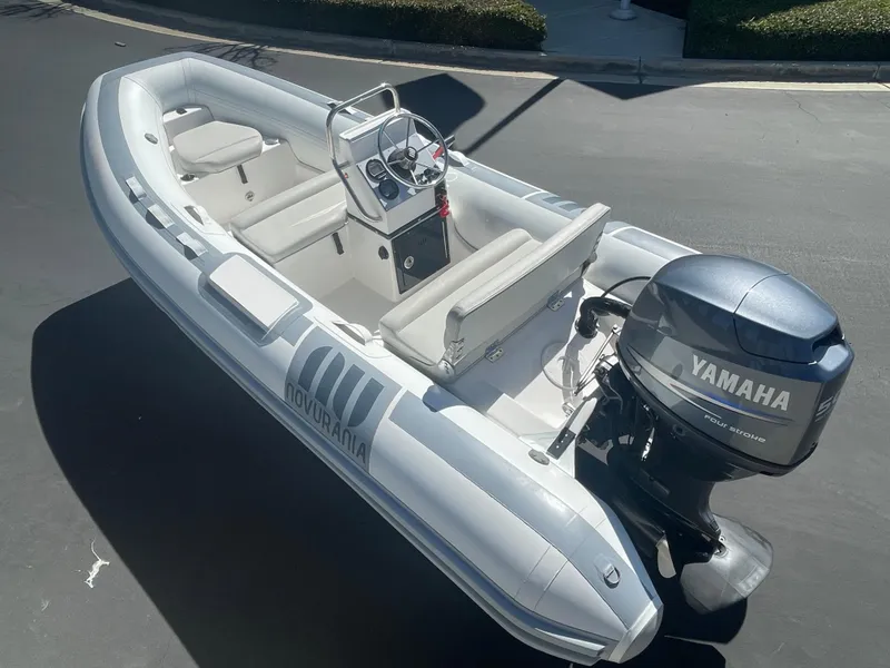 Slide: The Image of 2007 Novurania Deluxe 400 inflatable boat with Yamaha outboard motor, parked on pavement. - 14