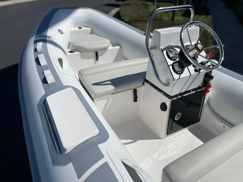 Slide: The Image of 2007 Novurania Deluxe 400 boat interior with steering console and seating. - 2