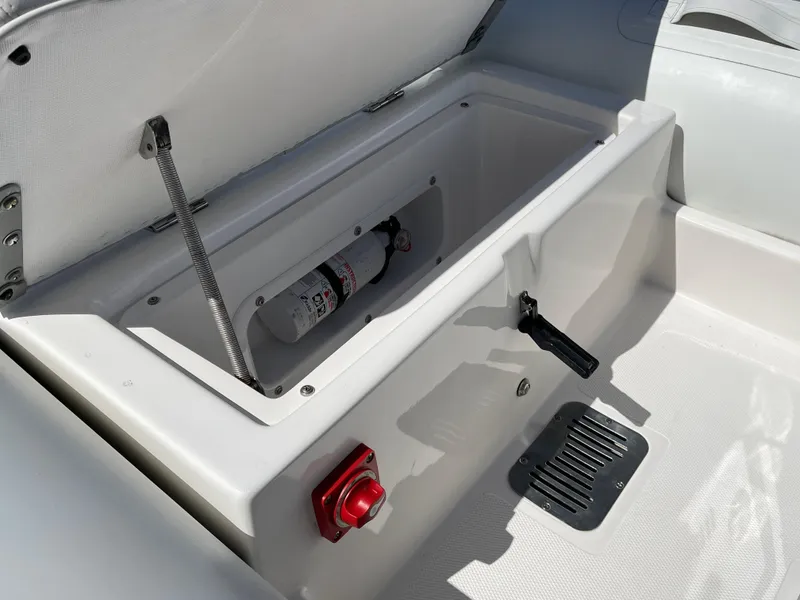 Slide: The Image of Open storage compartment in a 2007 Novurania Deluxe 400 boat, featuring a fire extinguisher. - 9