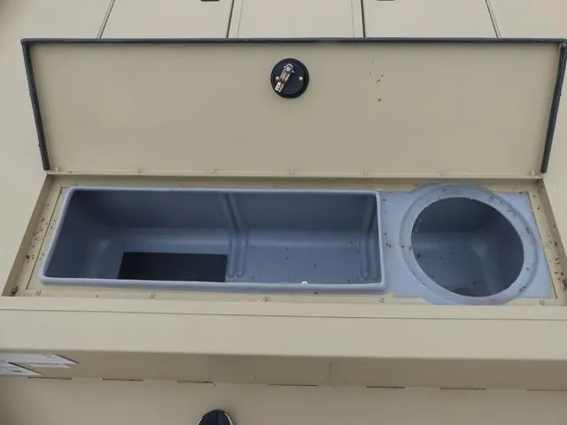 Slide: The Image of Open storage compartments on a 2025 Lowe rx20CC boat, with manuals inside. - 6