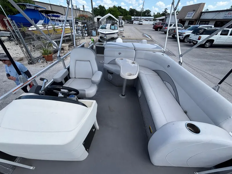Slide: The Image of 2013 Tahoe Pontoon AF 2280 FF with spacious seating and steering console, docked outdoors. - 12
