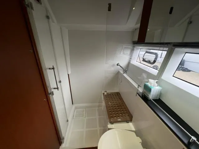 Slide: The Image of Bathroom interior of 2014 Jeanneau NC14 yacht, featuring modern fixtures and ample natural light. - 14