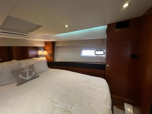 Slide: The Image of Luxurious cabin interior of 2014 Jeanneau NC14 yacht with cozy bedding and ambient lighting. - 16