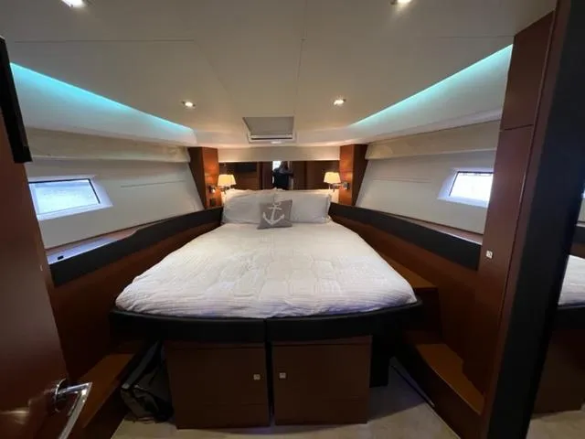Slide: The Image of Luxurious cabin interior of 2014 Jeanneau NC14 yacht with cozy bed and ambient lighting. - 19