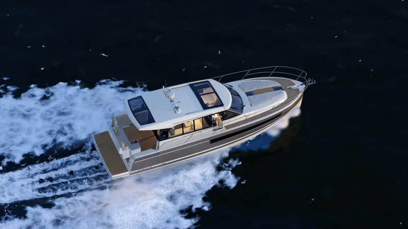 Slide: The Image of 2014 Jeanneau NC14 yacht cruising on open water, aerial view. - 2
