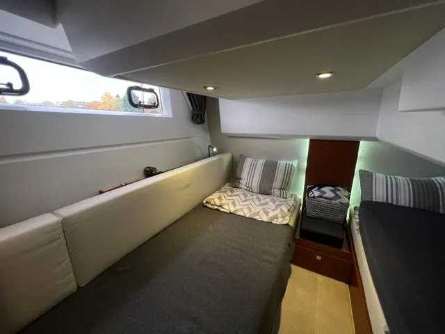 Slide: The Image of Cozy cabin interior of 2014 Jeanneau NC14 yacht with modern bedding and ambient lighting. - 20
