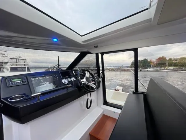 Slide: The Image of Interior view of 2014 Jeanneau NC14 boat cockpit with steering wheel and navigation system. - 25