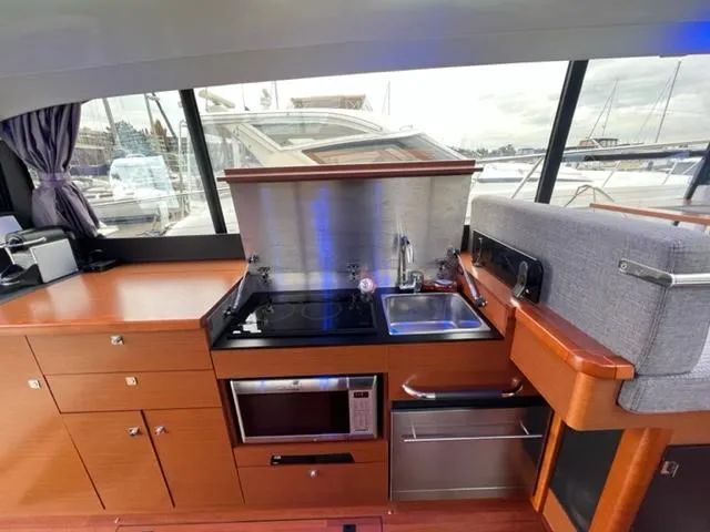 Slide: The Image of Modern kitchen area in a 2014 Jeanneau NC14 yacht with stove, sink, and microwave. - 27