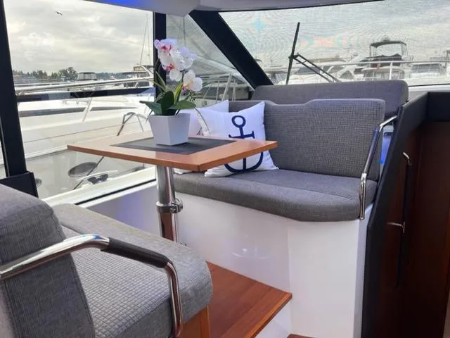 Slide: The Image of Interior of 2014 Jeanneau NC14 yacht with seating, table, and decorative pillow. - 29