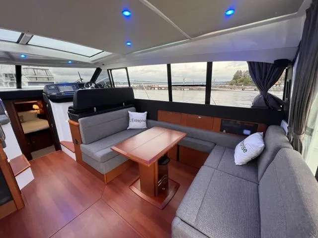 Slide: The Image of Luxurious interior of 2014 Jeanneau NC14 yacht with modern seating and panoramic windows. - 30