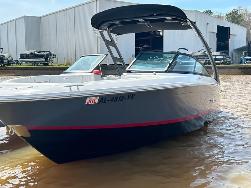 Slide: The Image of 2022 Regal LS2 boat docked near industrial buildings, featuring sleek design and modern features. - 2