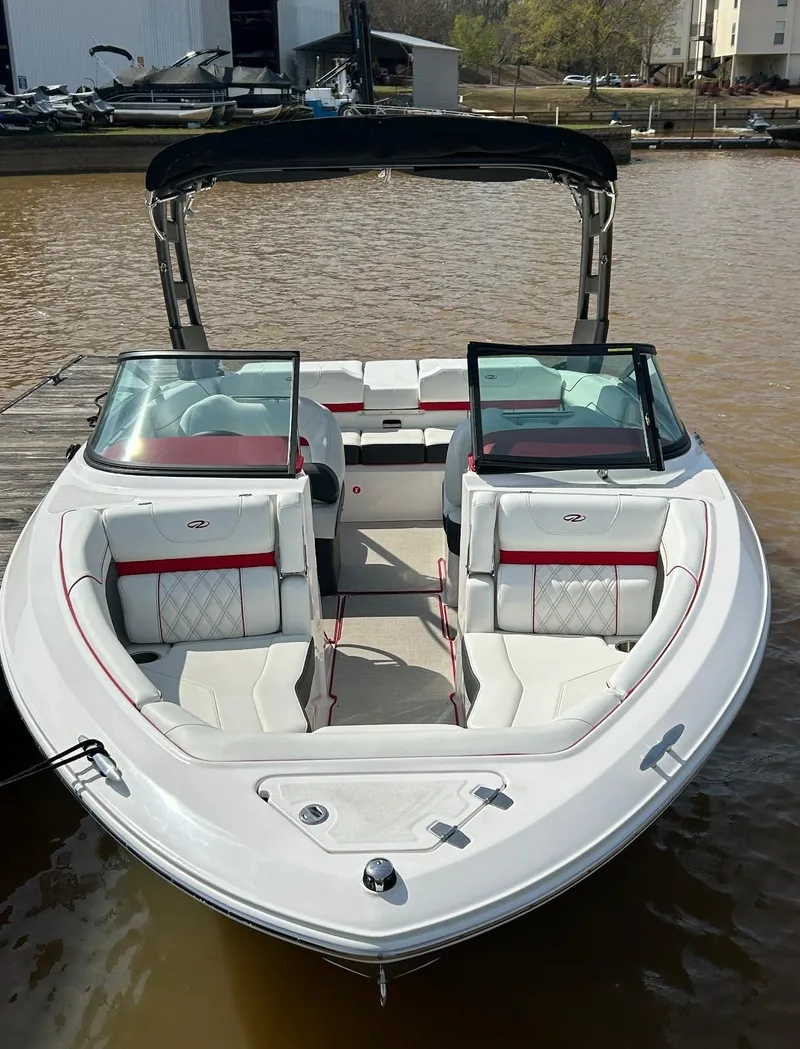 Slide: The Image of 2022 Regal LS2 boat with white and red interior, docked on a sunny day. - 3