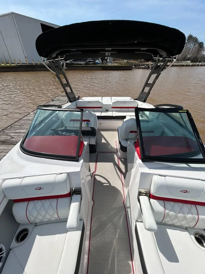 Slide: The Image of 2022 Regal LS2 boat with red and white interior, docked by a lake. - 4
