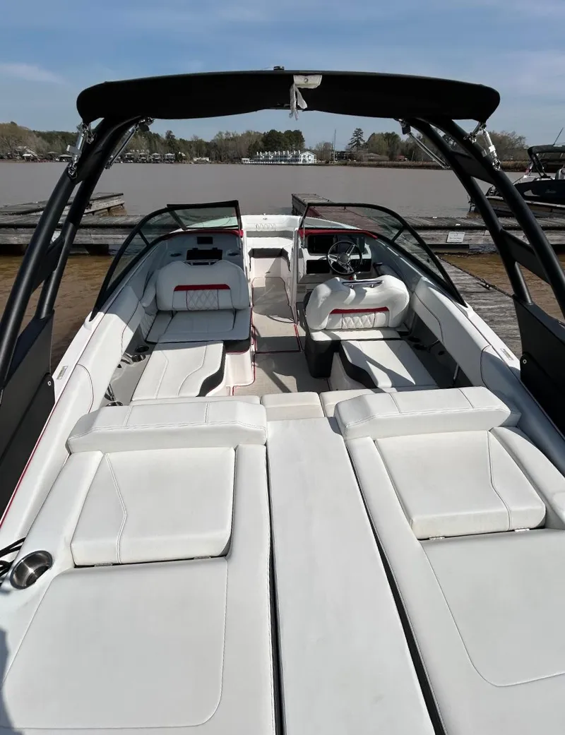 Slide: The Image of 2022 Regal LS2 boat with white seating, sleek design, and open deck on a sunny day. - 7