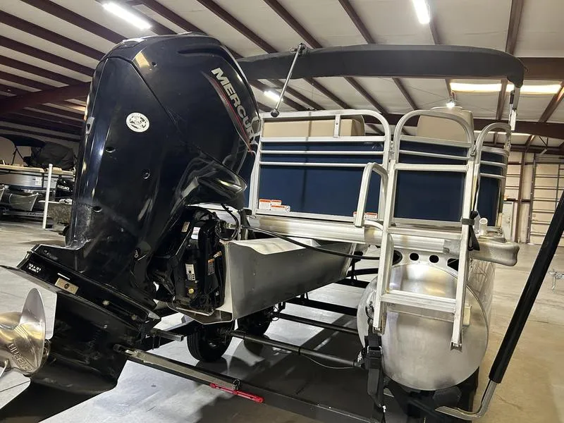 Slide: The Image of 2022 Sun Tracker PARTY BARGE® 20 DLX pontoon boat with Mercury outboard motor in a warehouse. - 10