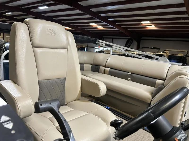 Slide: The Image of 2022 Sun Tracker PARTY BARGE® 20 DLX interior with beige seating and steering wheel. - 16