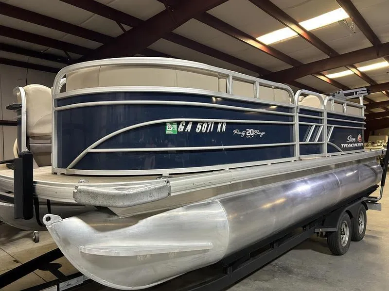 Slide: The Image of 2022 Sun Tracker PARTY BARGE® 20 DLX pontoon boat in a warehouse setting. - 3
