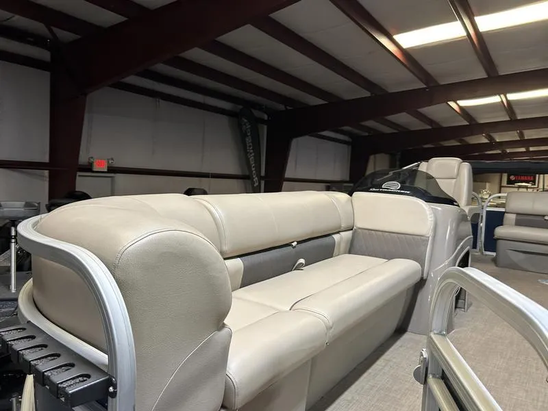 Slide: The Image of 2022 Sun Tracker PARTY BARGE® 20 DLX interior with beige seating in a showroom. - 4