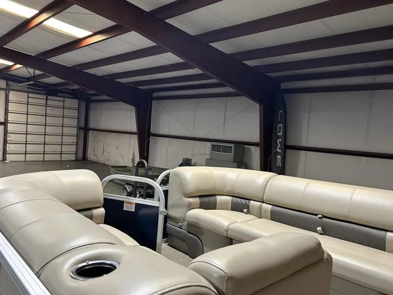 Slide: The Image of 2022 Sun Tracker PARTY BARGE® 20 DLX pontoon boat interior in a spacious warehouse. - 6
