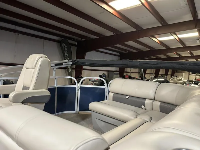 Slide: The Image of 2022 Sun Tracker PARTY BARGE® 20 DLX interior with beige seating in a showroom. - 8