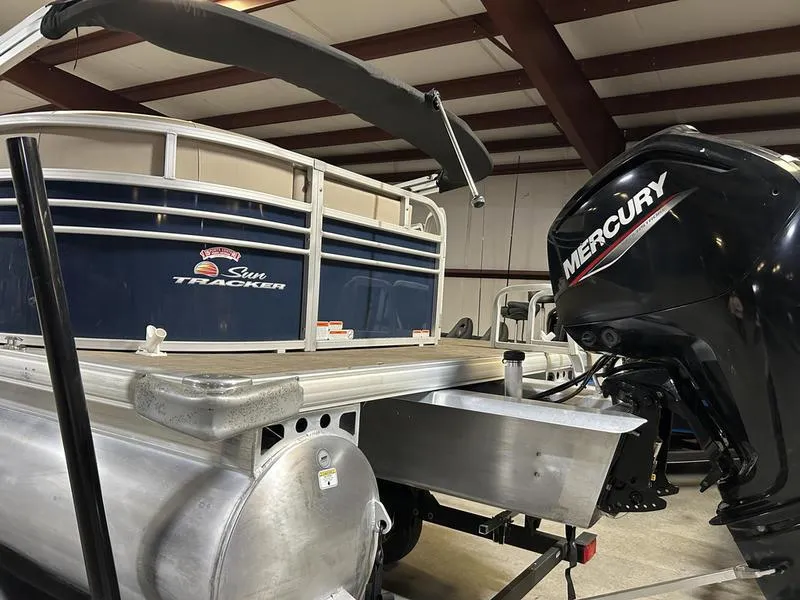 Slide: The Image of 2022 Sun Tracker PARTY BARGE® 20 DLX pontoon boat with Mercury outboard motor in a showroom. - 9