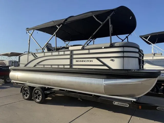 Slide: The Image of 2025 Bennington 22 S Cruise Jump pontoon boat on trailer, featuring sleek design and canopy. - 3