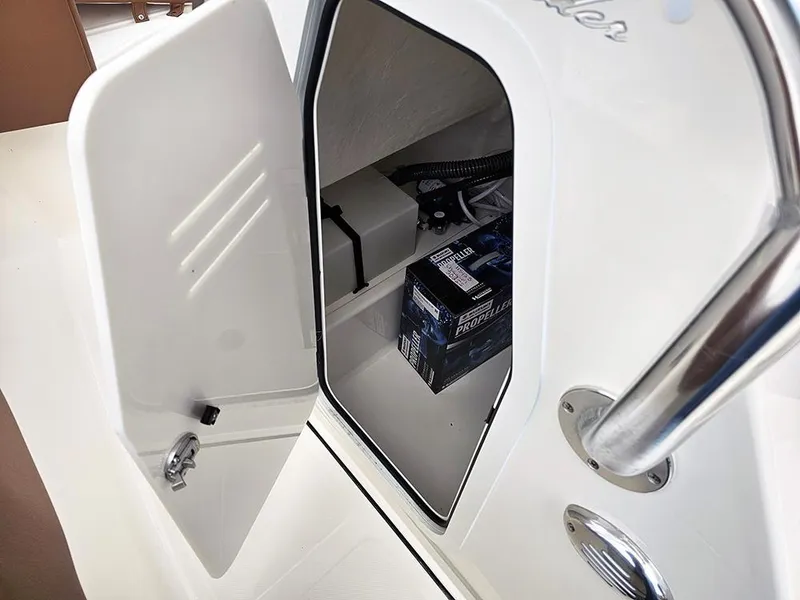 Slide: The Image of 2025 Pioneer 202 Islander boat storage compartment with open door, revealing interior contents. - 15