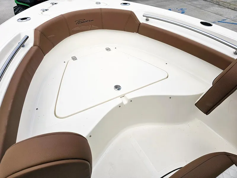 Slide: The Image of 2025 Pioneer 202 Islander boat interior with brown seating and white deck. - 17
