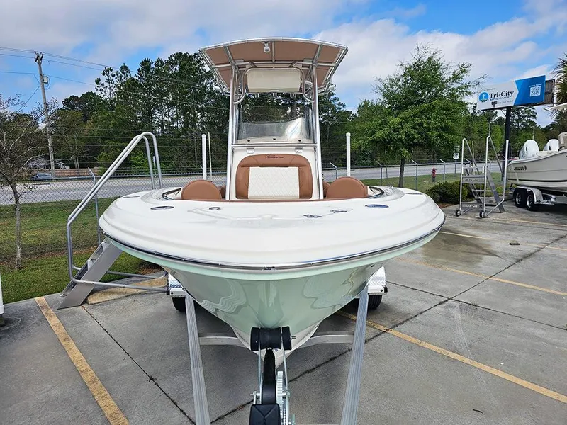 Slide: The Image of 2025 Pioneer 202 Islander boat on trailer, parked outdoors under a blue sky. - 4