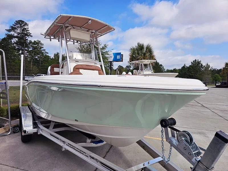 Slide: The Image of 2025 Pioneer 202 Islander boat on trailer, parked outdoors under a partly cloudy sky. - 5