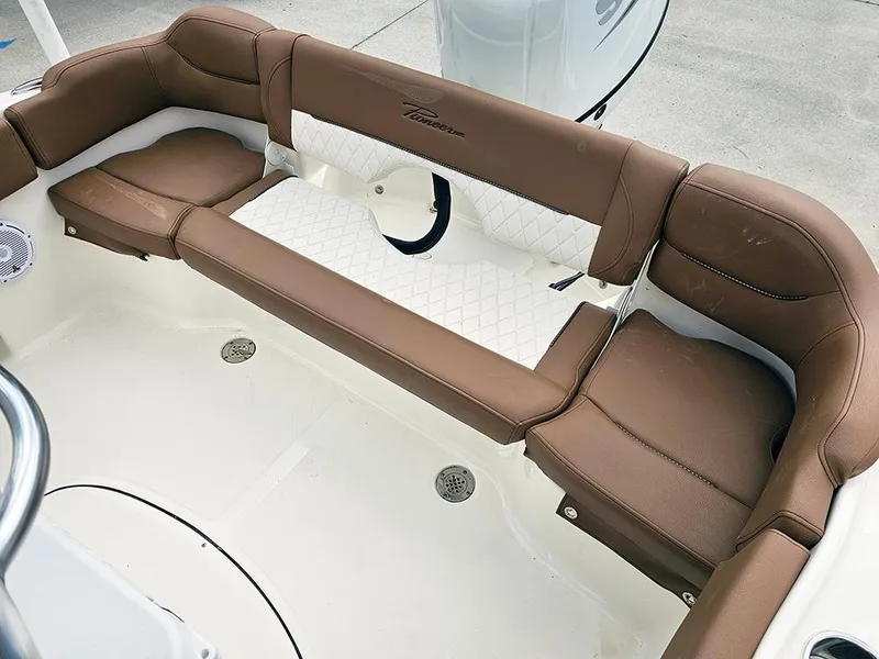 Slide: The Image of 2025 Pioneer 202 Islander boat interior with brown cushioned seating and white flooring. - 7