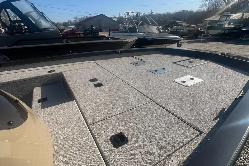 Slide: The Image of 2025 G3 Sportsman 1810 PFX boat deck with storage compartments, docked outdoors. - 6