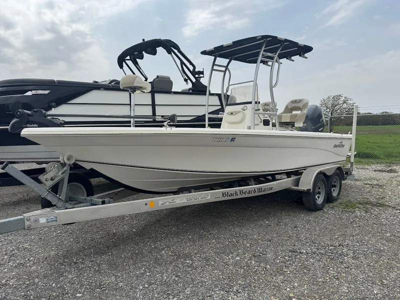 Slide: The Image of 2015 NauticStar 2110 Sport boat on trailer, parked outdoors. - 0