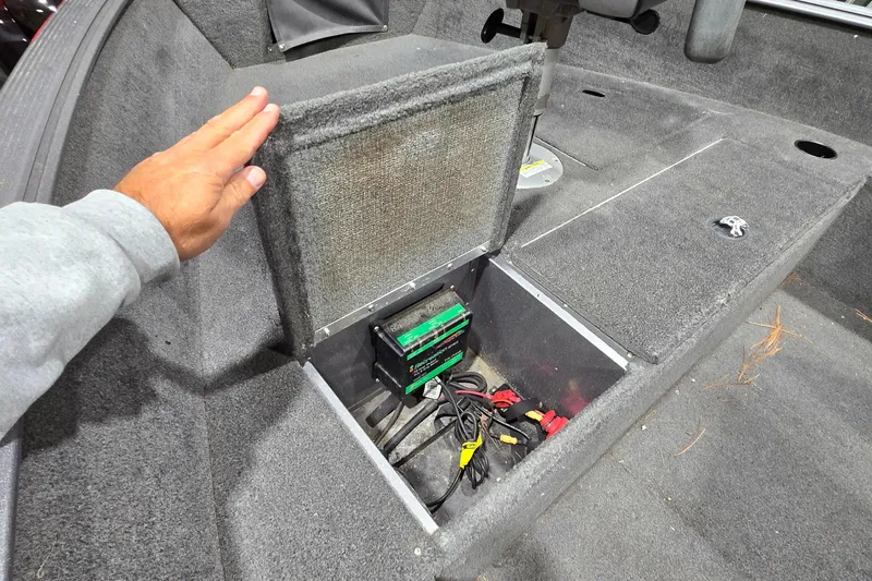Slide: The Image of 2014 Lund 1650 Rebel Tiller boat battery compartment with wiring and charger visible. - 3