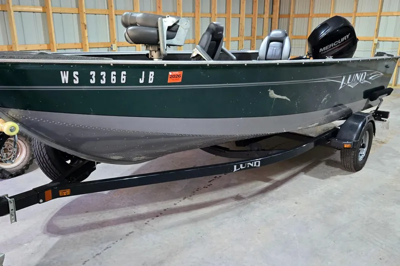 Slide: The Image of 2014 Lund 1650 Rebel Tiller boat on trailer in a garage setting. - 6