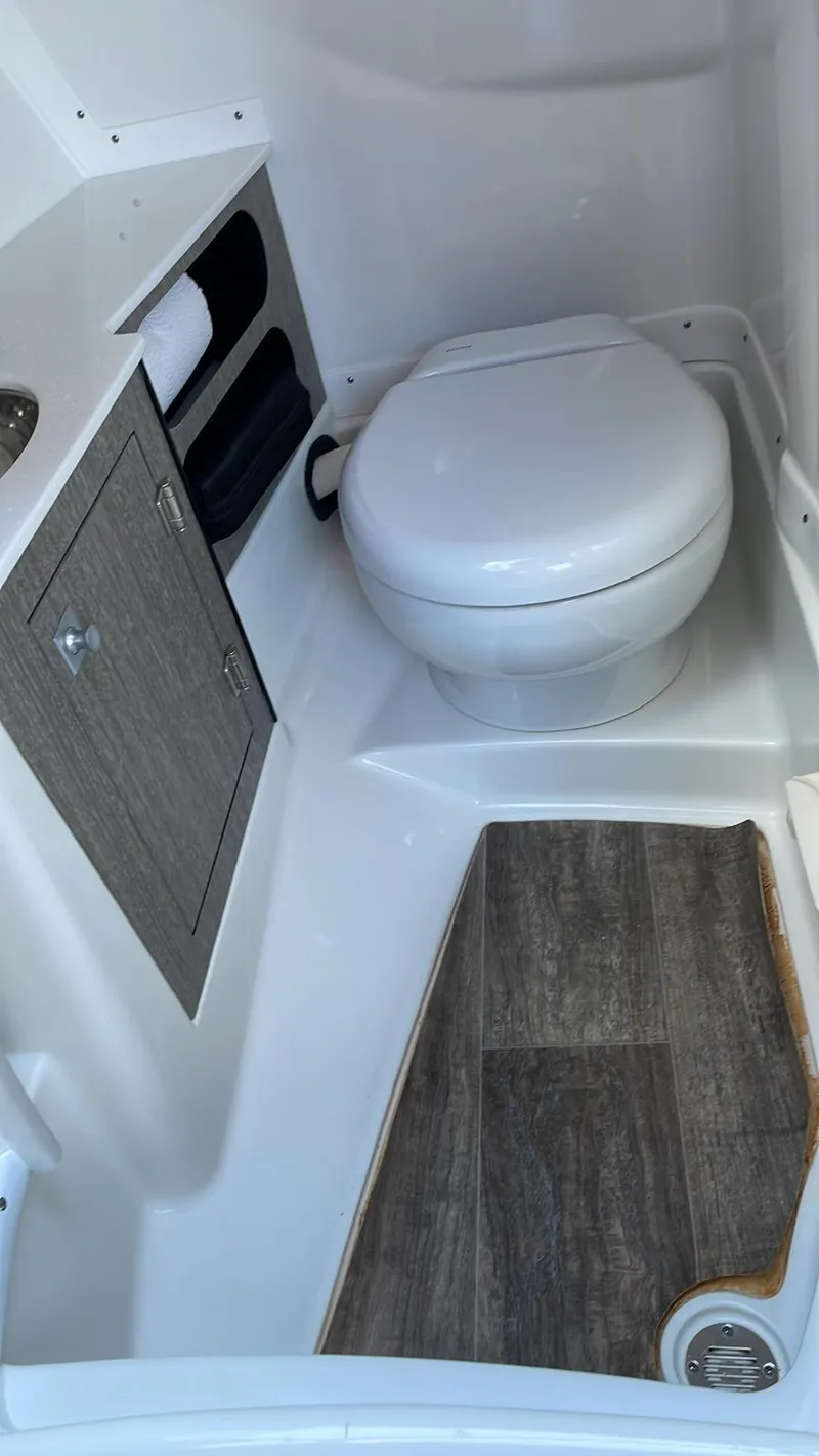 Slide: The Image of 2022 Monterey 275 Super Sport boat bathroom with toilet and storage cabinet. - 16