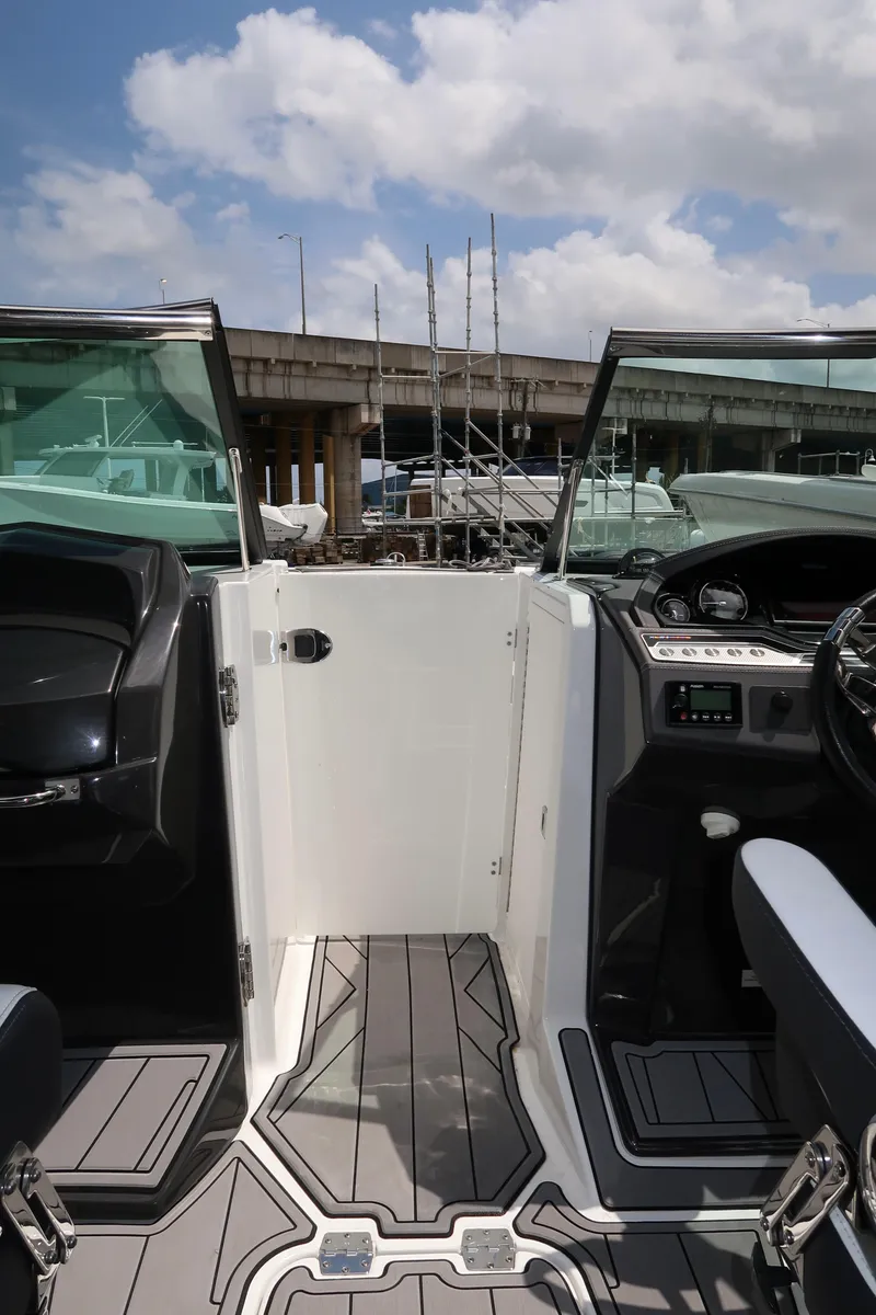 Slide: The Image of 2022 Monterey 275 Super Sport boat interior with open door, sleek design, and modern dashboard. - 9