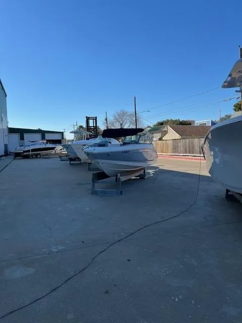 Slide: The Image of 2020 Chaparral 23 SSi boat on display outdoors under clear blue sky. - 10